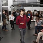 Colour photograph of a number of people taking part in the set up of a live performance in the Information Age gallery