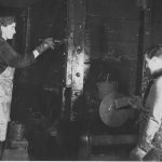 Black and white photograph of a man and a woman painting a railway carriage