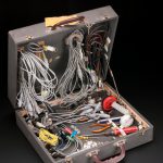 A suitcase containing a variety of small electrical tools