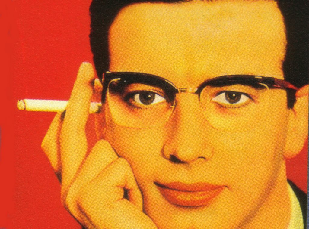 Colour print advertisement showing a man wearing Nylor supra frame spectacles and holding a cigarette