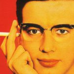 Colour print advertisement showing a man wearing Nylor supra frame spectacles and holding a cigarette