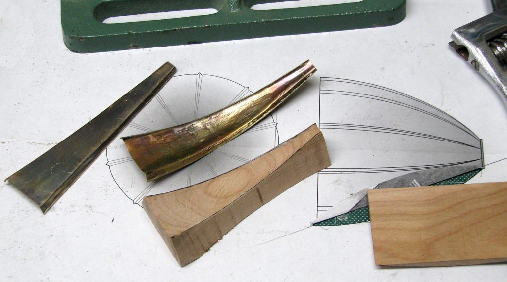 Colour photograph of strips of brass used to fabricate a mouthpiece