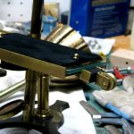 Colour photograph of a glass plate smoked with soot from a candle flame installed on top of the glass bed of the brass stage