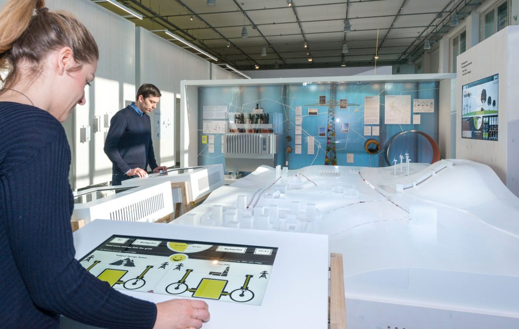 Colour photograph of museum visitors viewing a display on renewables