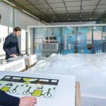 Colour photograph of museum visitors viewing a display on renewables
