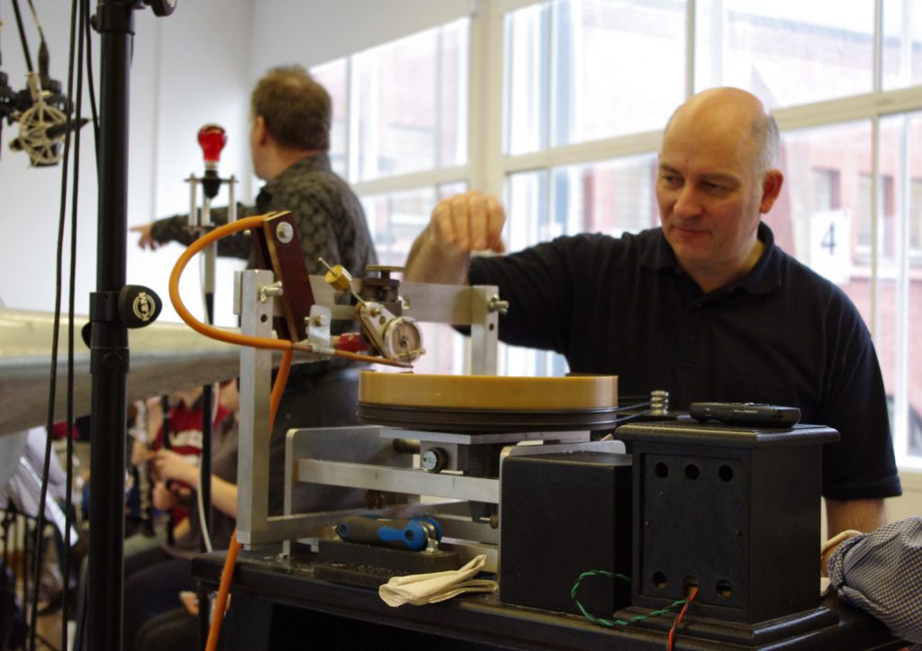 Colour photograph of a man operating the disc recording lathe