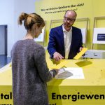Colour photograph of a museum visitor being given an information leaflet