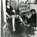 Black and white photograph of a neurologist seated before a female patient