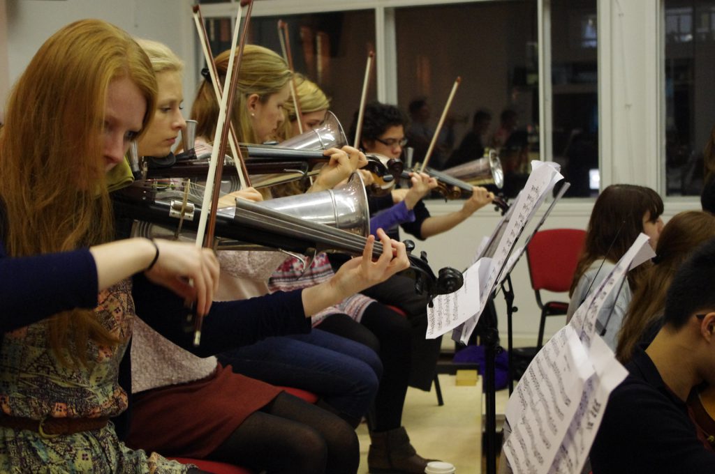 Colour photograph of members of RCM playing Stroh instruments