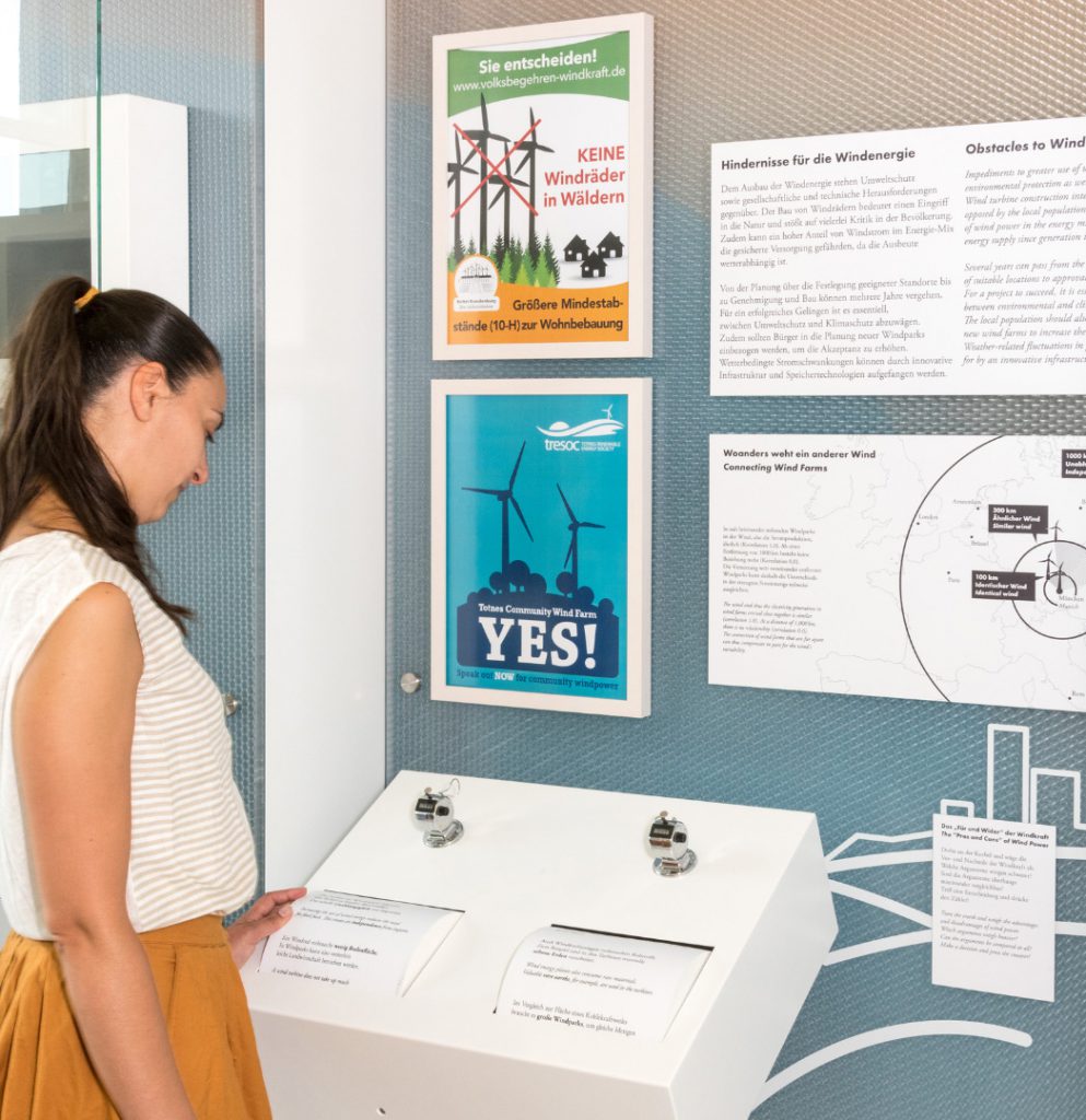 Colour photograph of a museum visitor interacting with a display case