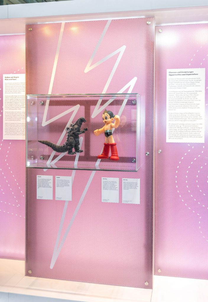Colour photograph of Godzilla and Astro Boy models on display in a glass case