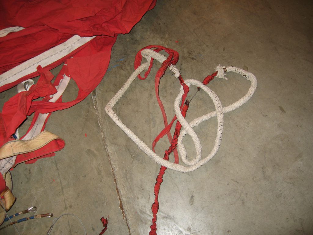 Colour photograph of a large deflated hot air balloon canvas spread on the floor of a warehouse