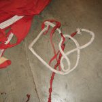 Colour photograph of a large deflated hot air balloon canvas spread on the floor of a warehouse