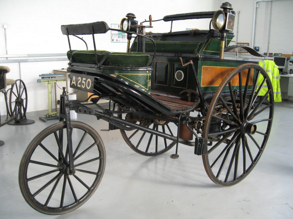 Colour photograph of a three wheeled car from the 1800s