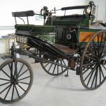 Colour photograph of a three wheeled car from the 1800s