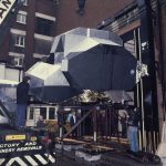 Colour photograph of a moon landing unit being winched into a warehouse at the Science Museum London