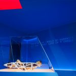 Colour photograph of a section of the Cosmonauts exhibition showing a mannequin lying inside a spacecraft seat