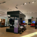 Colour photograph of a Teddy Boys jacket and photographs showing previous wearers of displayed items on display in an exhibition gallery