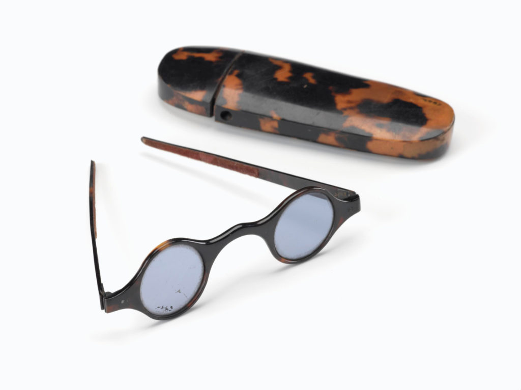 Colour photograph of tortoiseshell straight spectacle frames lined with velvet