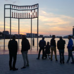 Colour photograph of evening visitors to an AIDS monument in Amsterdam