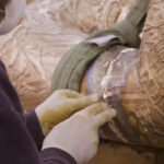 Colour photograph of a sculptor working on the Self Conscious Gene sculpture