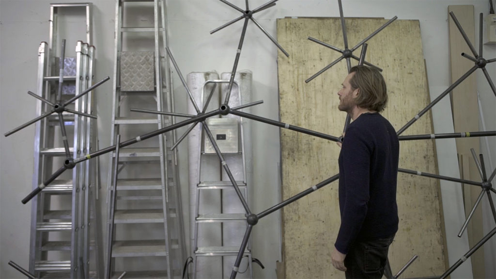 Colour photograph of an artist during the construction of the Bloom light installation