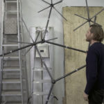 Colour photograph of an artist during the construction of the Bloom light installation