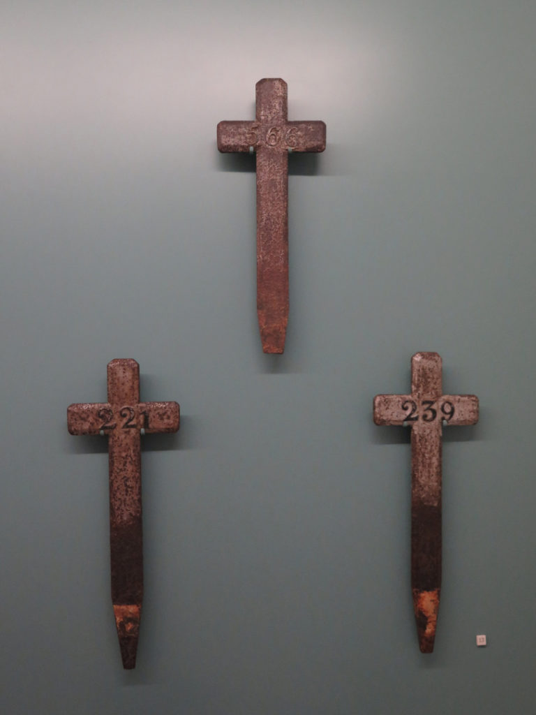 Colour photograph of cross grave markers on display