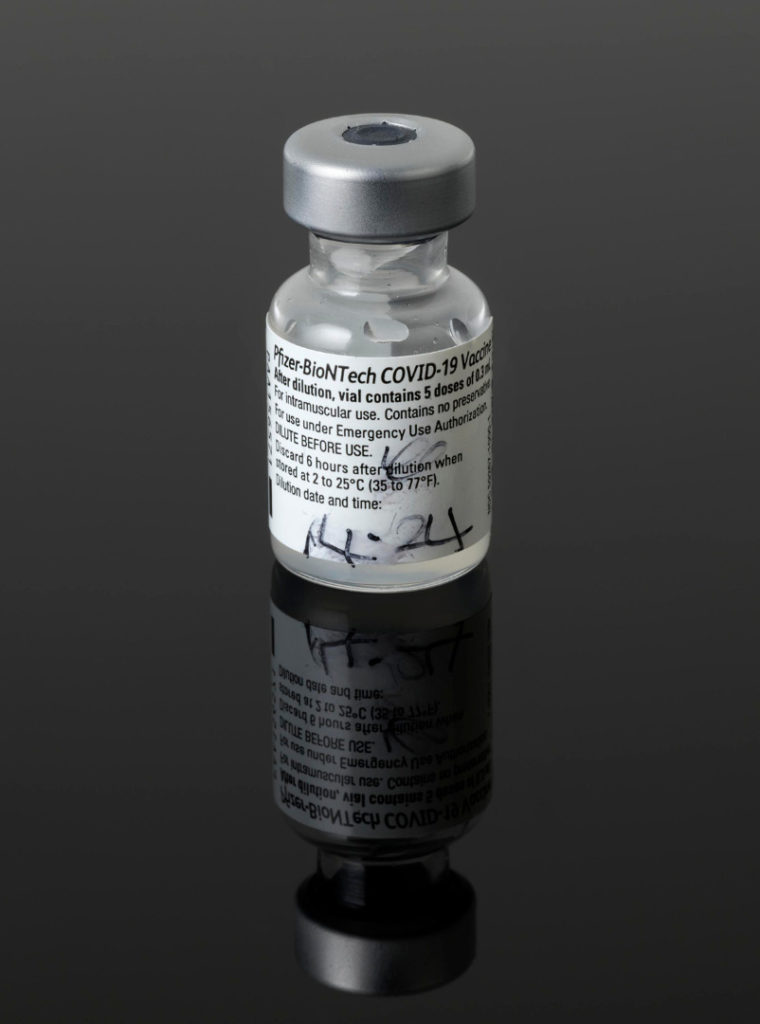 Colour photograph of the first used COVID vaccine bottle
