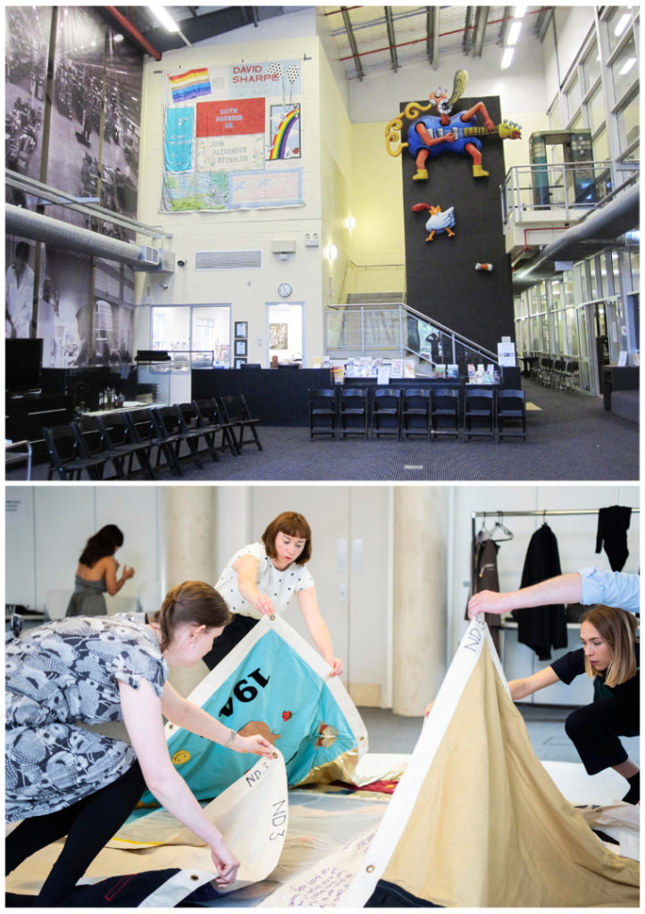 Colour photograph of a section of the Australian AIDS memorial quilt on display in Sydney and museum curators unfolding an AIDS memorial quilt