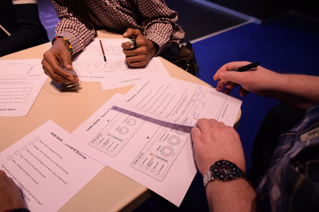 Colour photograph of audience listeners collaborating in prototype design discussions
