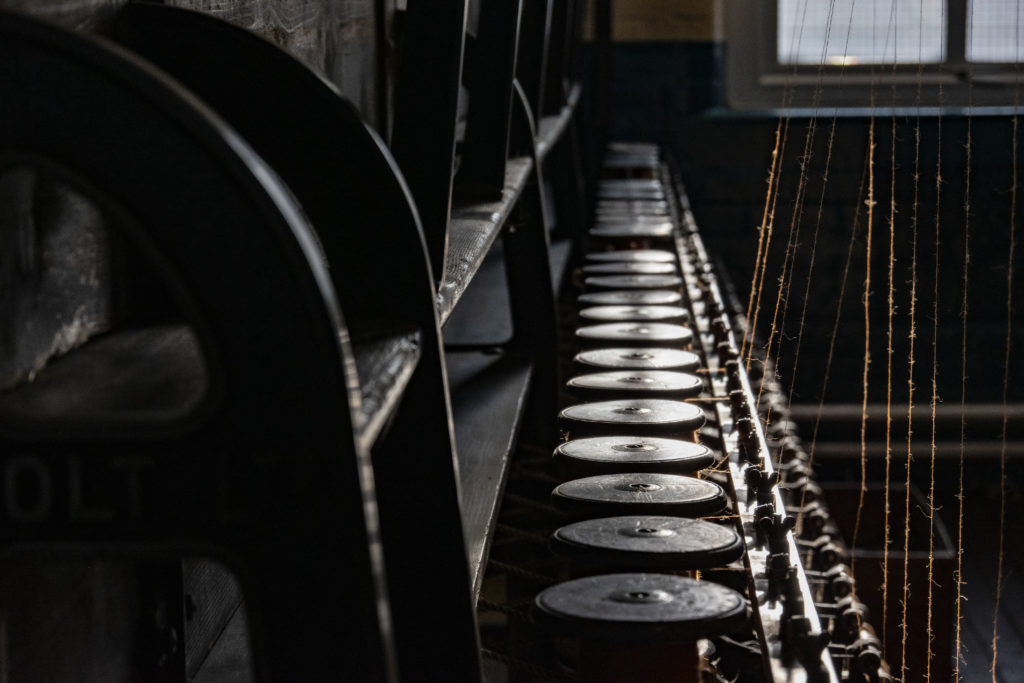 Colour photograph of threads in a yarn machine at Bradford Industrial Museum