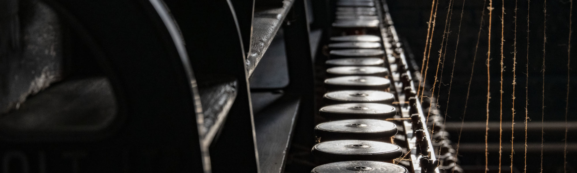 Colour photograph of threads in a yarn machine at Bradford Industrial Museum