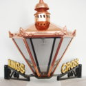 Colour photograph of a copper Victorian style lamp with KINGS CROSS letters in gold