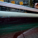 Photograph of a man preparing the warp threads on a Jacquard loom