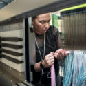 Photograph of a woman preparing a warp on a Jacquard loom