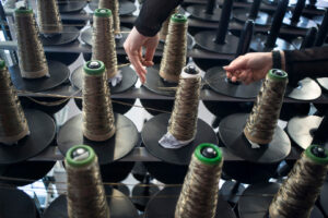 Photograph of someone loading a creel of fibres made from basalt