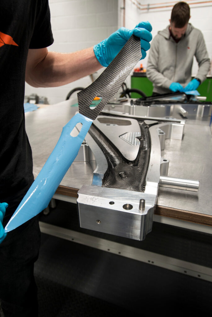 Photograph of a worker Inserting woven carbon combined with resin into moulds