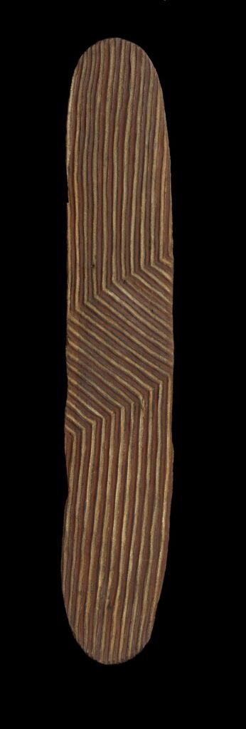 Colour photograph of a carved and pigmented shield made of wood