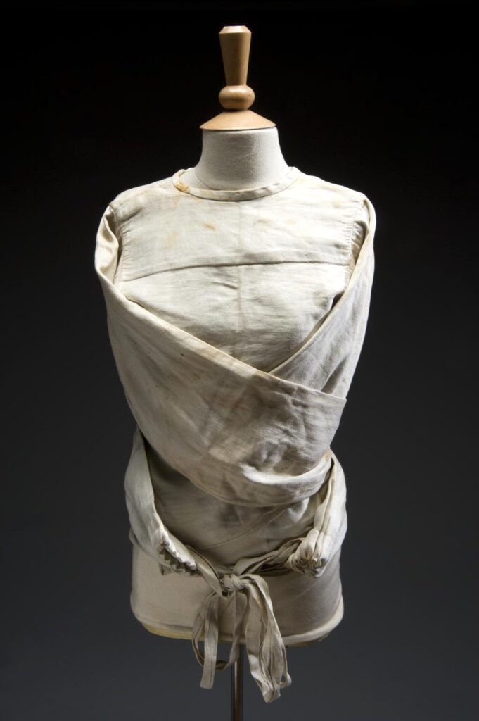 Colour photograph of a canvas straitjacket for restraining adult patients